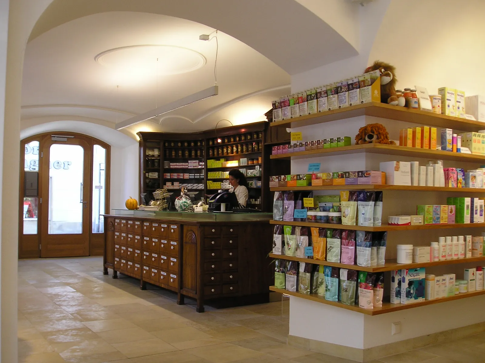 Verkaufsraum der Löwen-Apotheke mit Gewölbe, historischen Holzladen und Regalen voller Pflegeprodukte