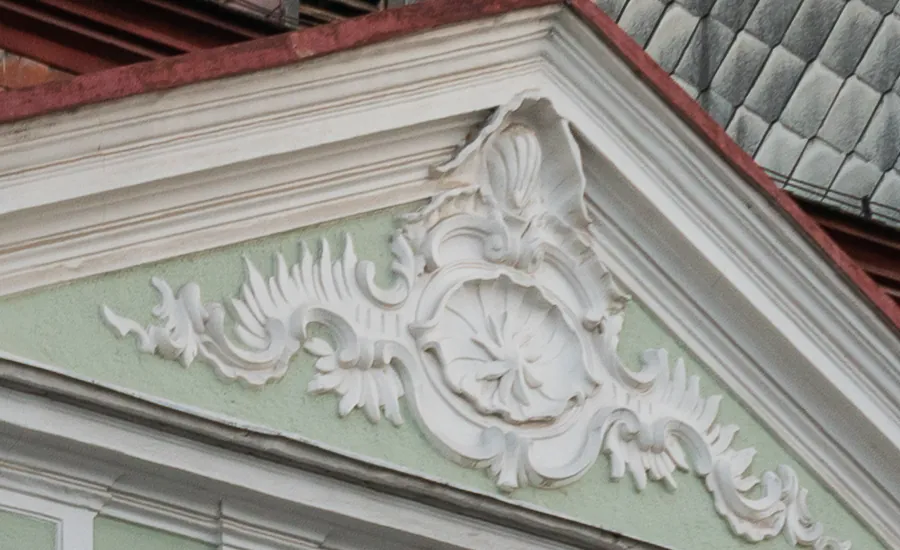 Barockes Stuckornament mit Muschel und Rankenwerk im Giebel der Apotheke
